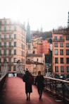 people walking on bridge near buildings during daytime