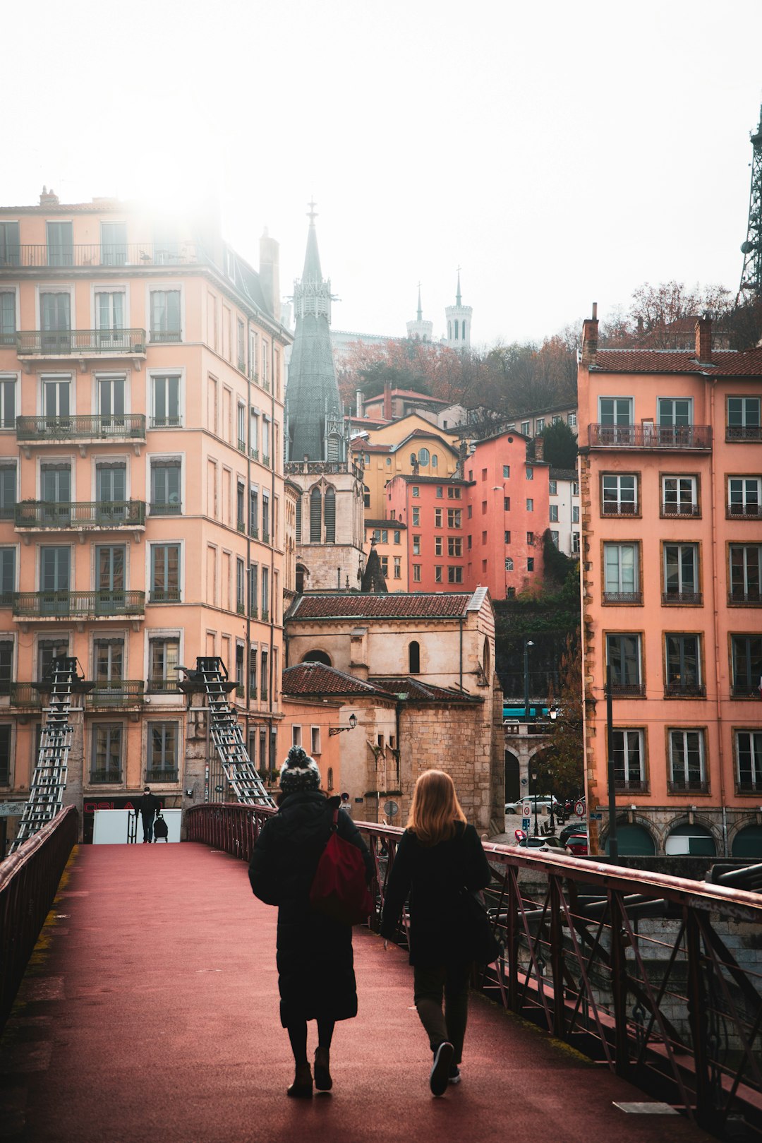 people walking on bridge near buildings during daytime