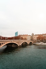 white boat on body of water near bridge during daytime