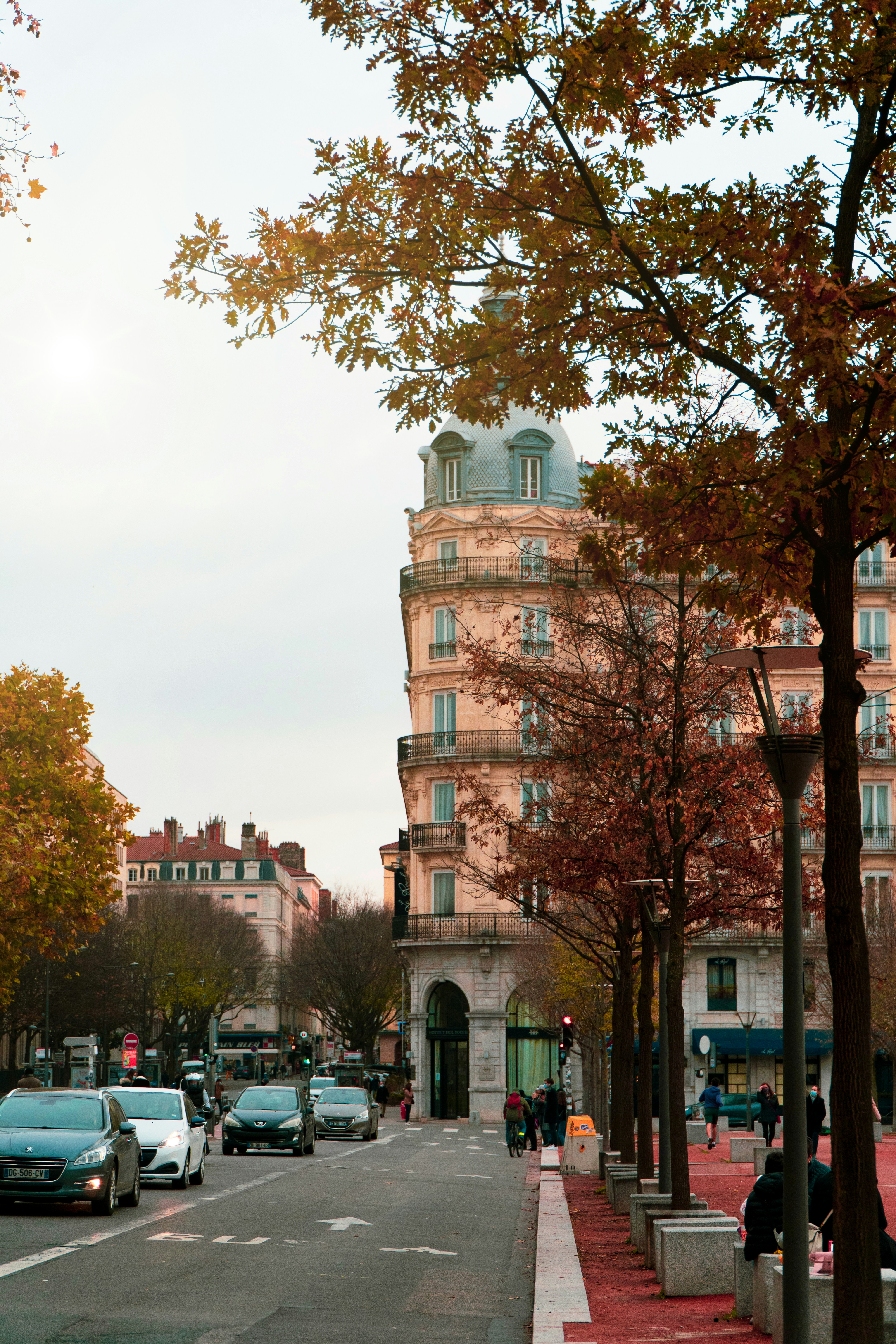 cars parked on side of road near brown concrete building during daytime