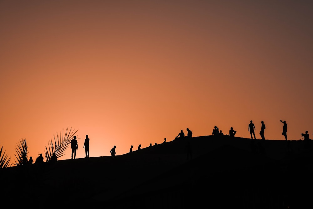 夕暮れ時の山の人々のシルエット