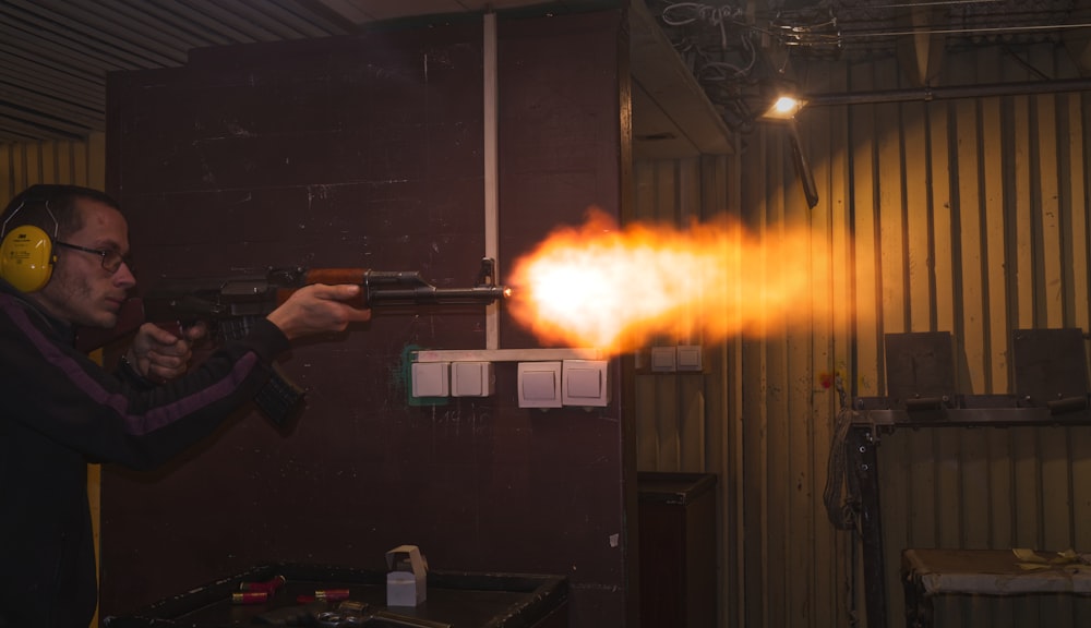 person holding black rifle with fire