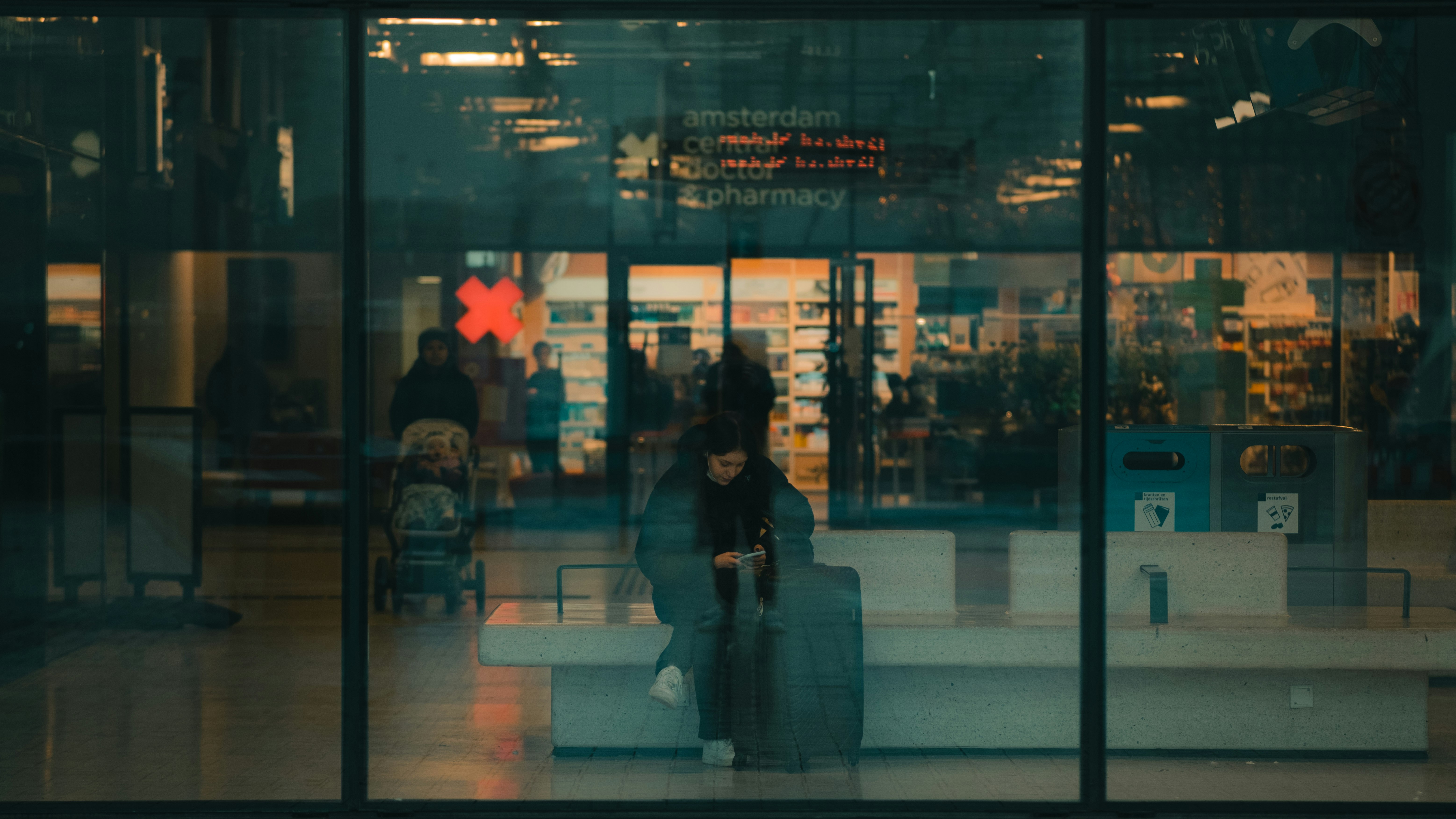 woman in black coat standing in front of glass wall