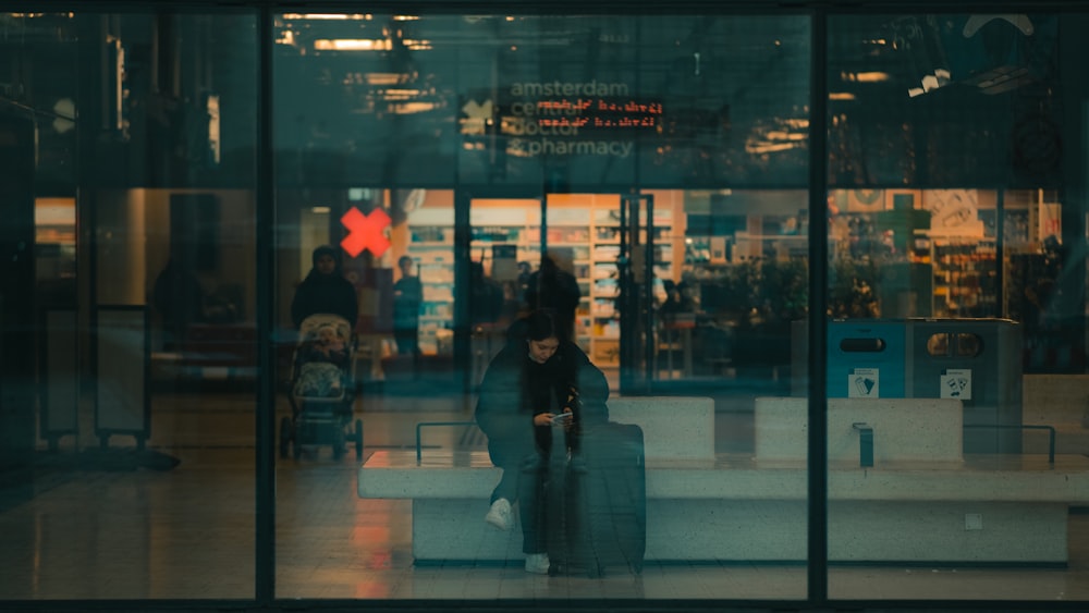 woman in black coat standing in front of glass wall