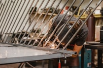 person in black t-shirt and black shorts standing on gray metal frame
