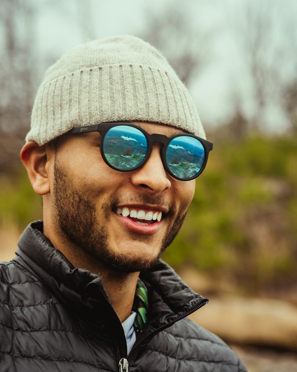 man in black jacket wearing gray knit cap and black framed sunglasses