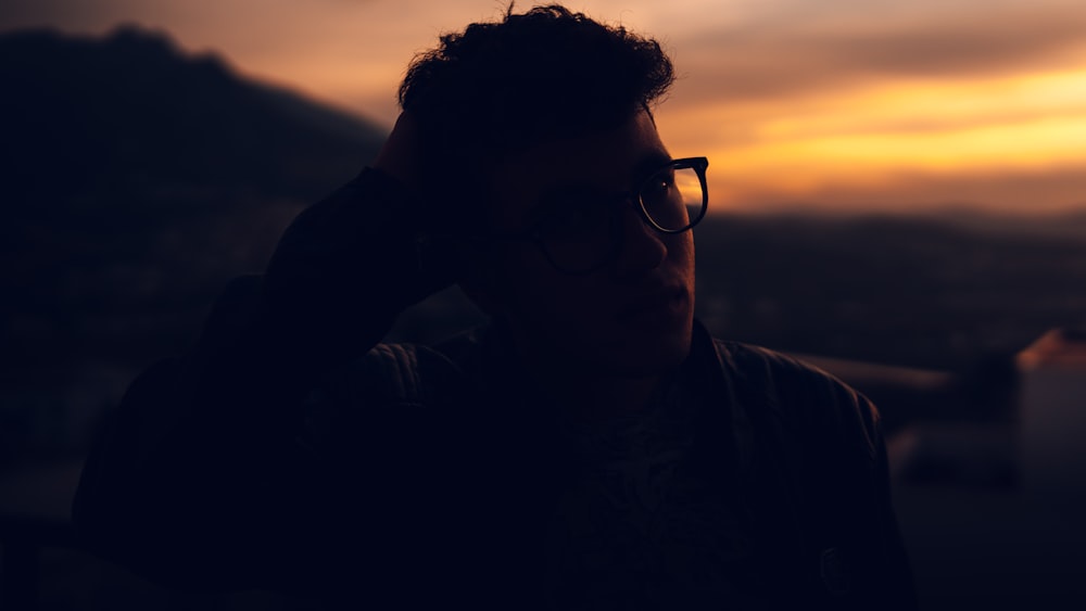 man in black framed eyeglasses and black jacket