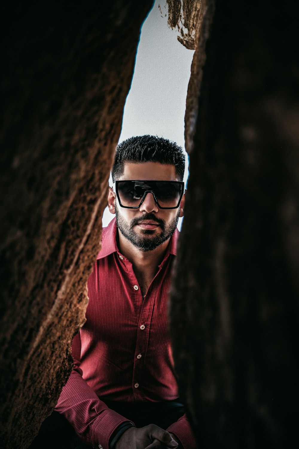 man in red button up shirt wearing white framed sunglasses