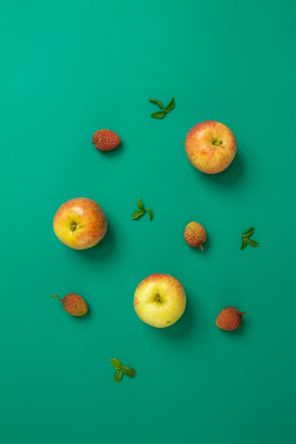 sliced apple and strawberries on pink surface