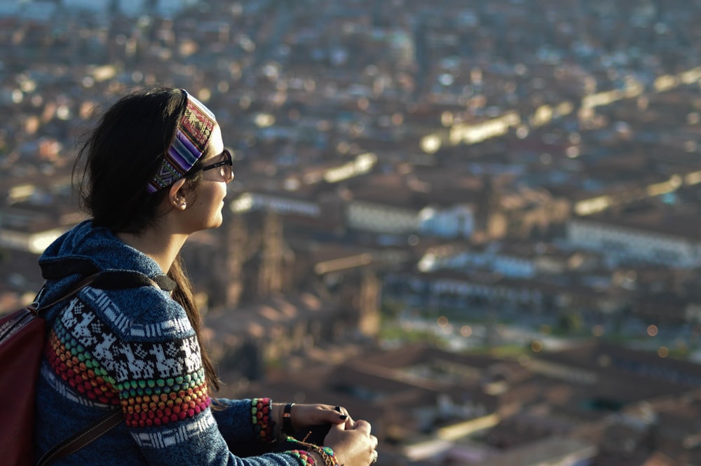 woman in blue and red scarf looking at the city during daytime