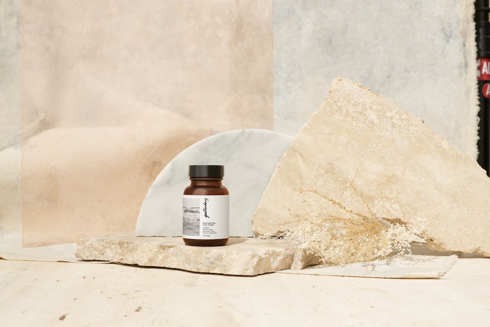 brown and white plastic bottle on white sand