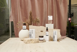 Close-up of elegant skincare products arranged on a marble countertop with soft natural lighting.