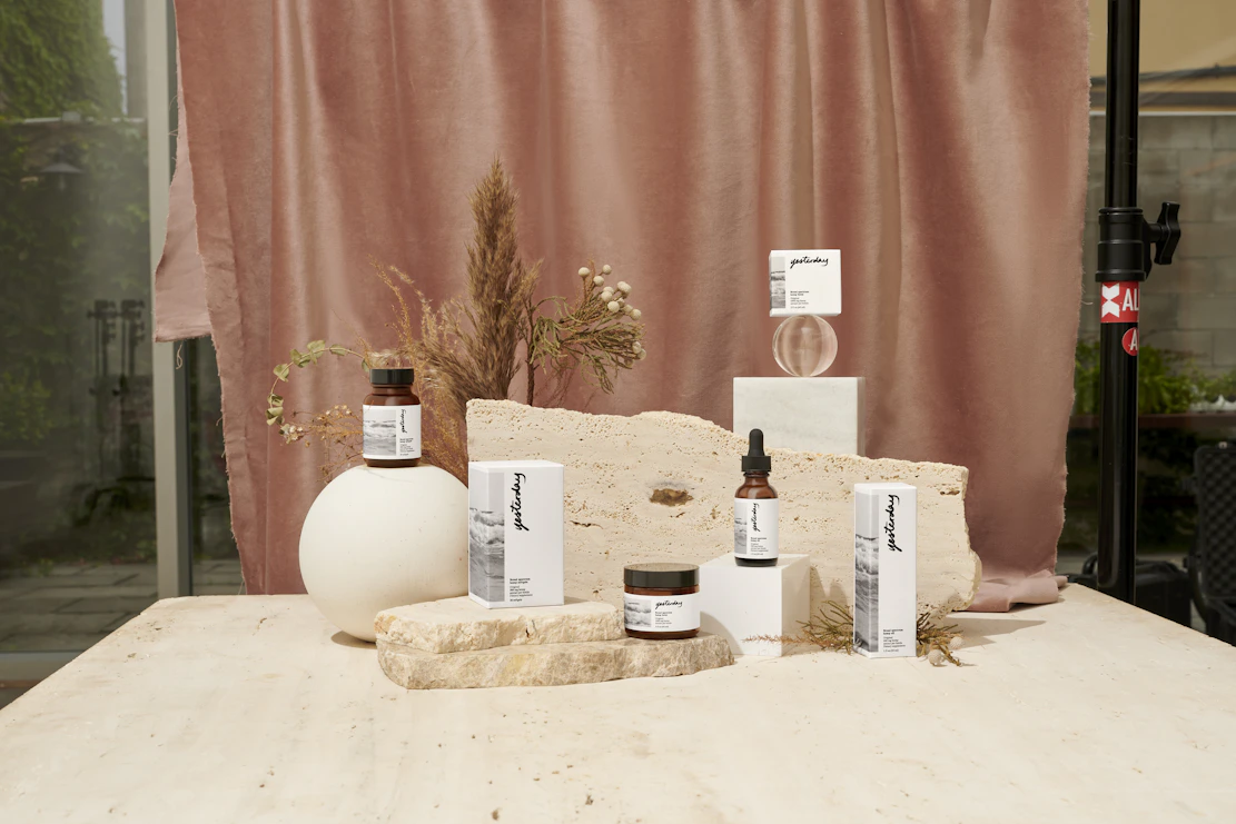Close-up of vibrant skincare products arranged on a marble countertop with soft natural light.