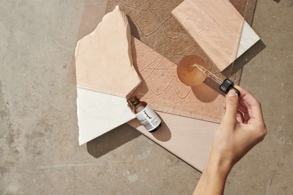 person holding brown glass bottle