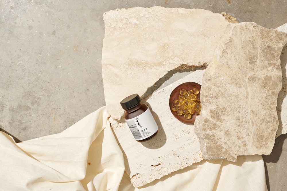 brown glass bottle on white textile