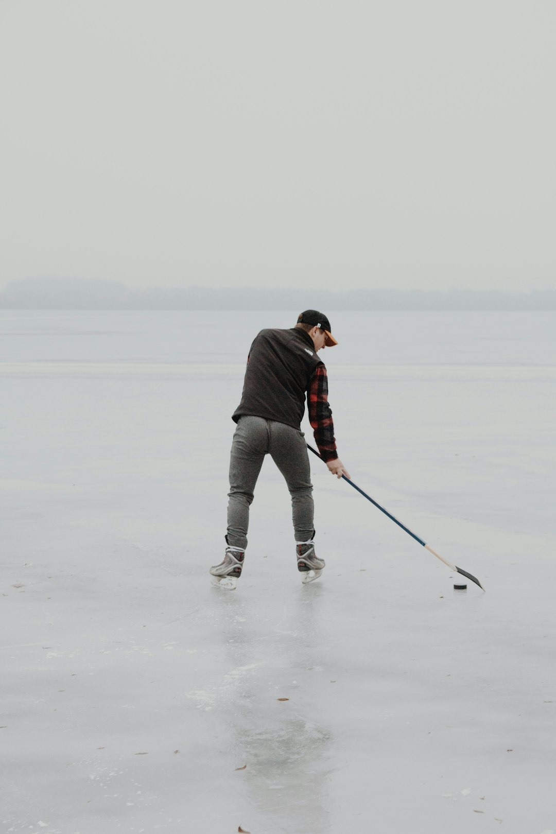 man in black jacket and gray pants holding black and white stick