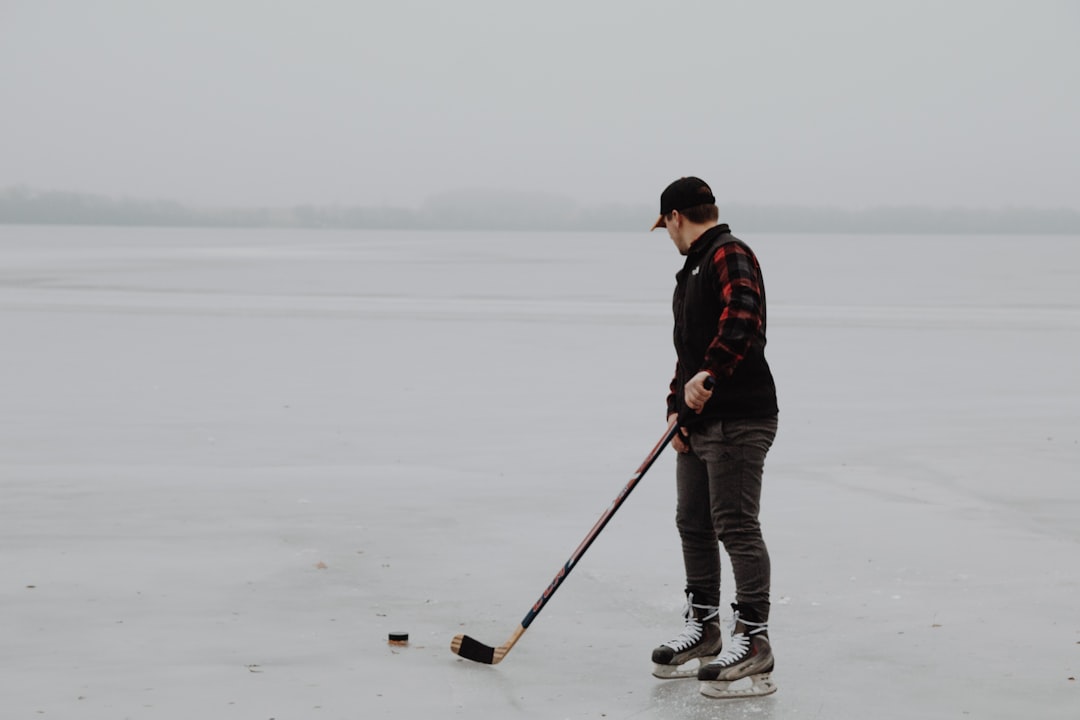 man in black jacket and black pants holding stick standing on snow covered ground during daytime