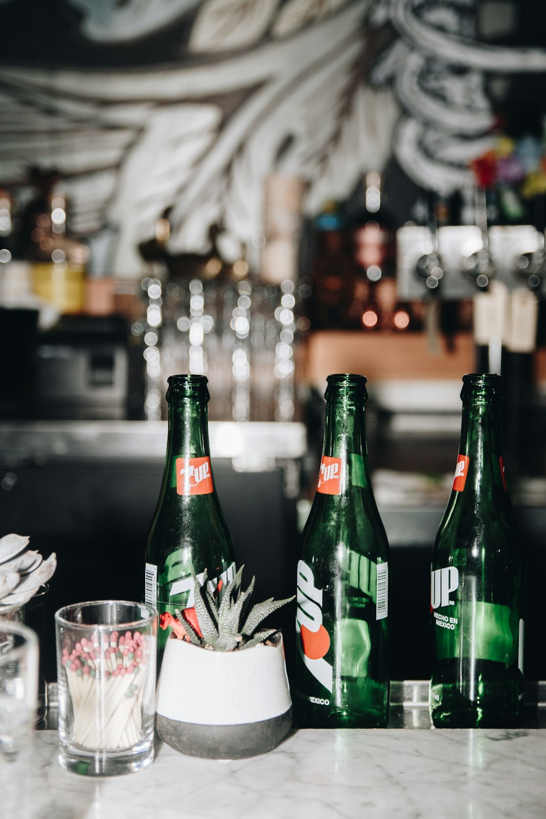 green glass bottle beside clear drinking glass