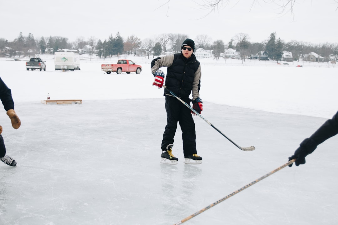 man in black jacket and pants playing ice hockey