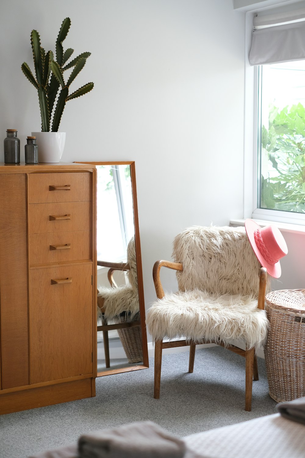 Silla de madera blanca y marrón junto a un mueble de madera marrón
