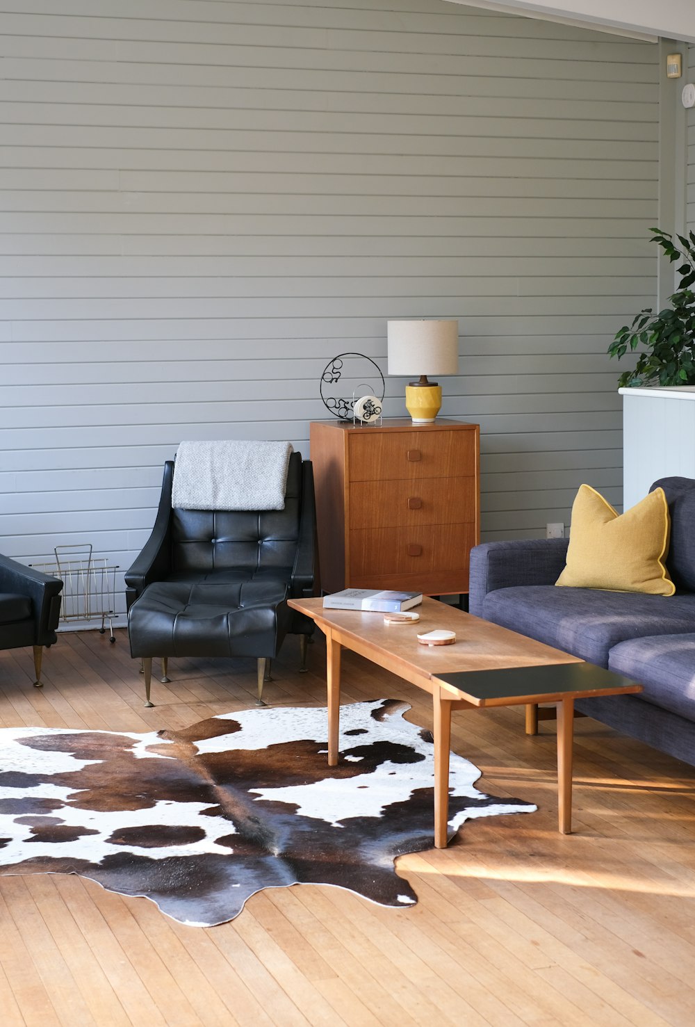 Cajón marrón de madera de 3 capas junto al sillón de cuero negro