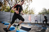 man in black crew neck t-shirt and black shorts running on blue and white trampoline