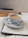 An open notebook with handwritten poetry beside a cup of tea.