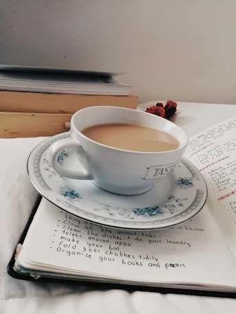 A calm workspace with soft purple lighting and a notebook open next to a cup of tea.