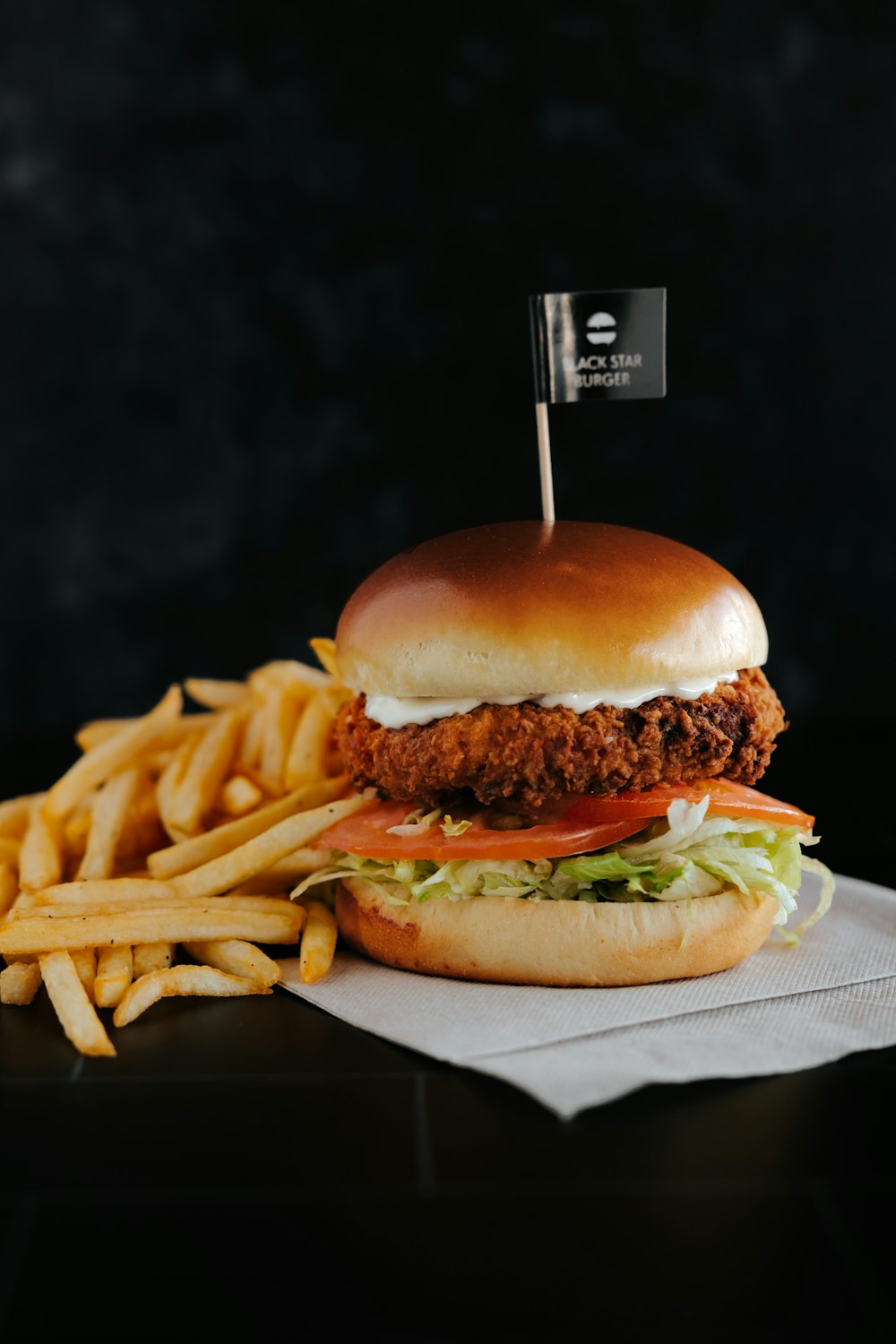 Hamburguesa con patatas fritas sobre papel blanco