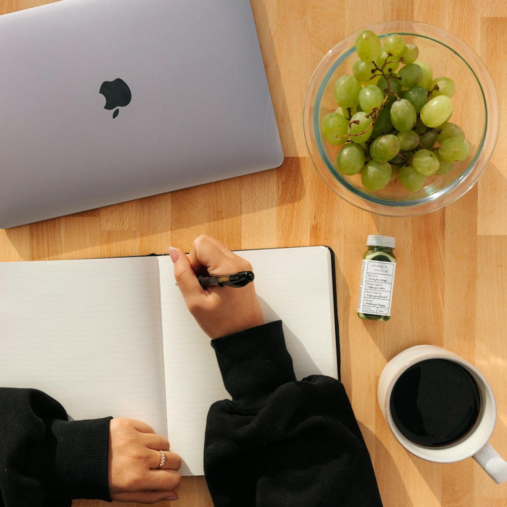 person holding white paper with green grapes