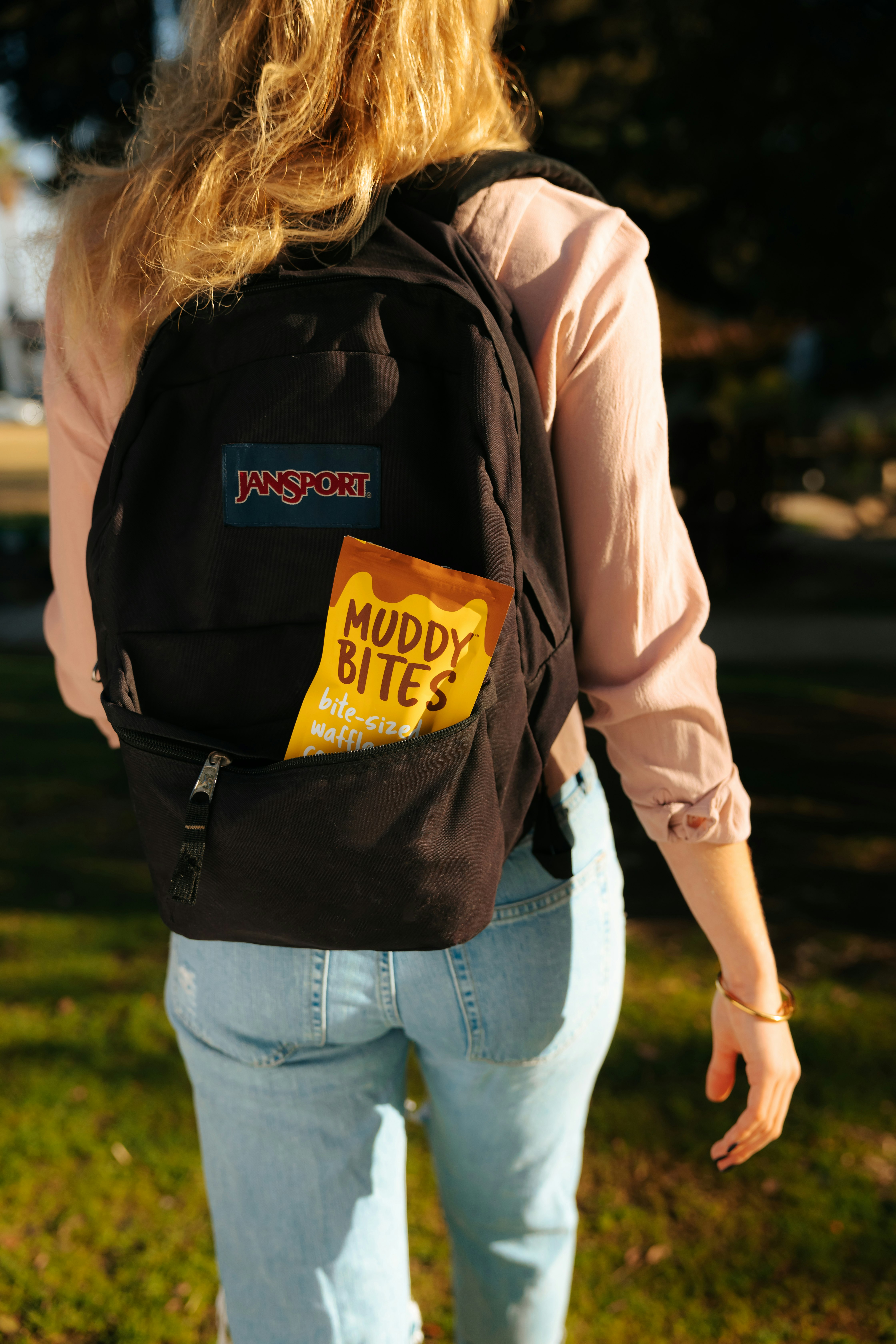 woman in brown jacket and blue denim jeans with black backpack
