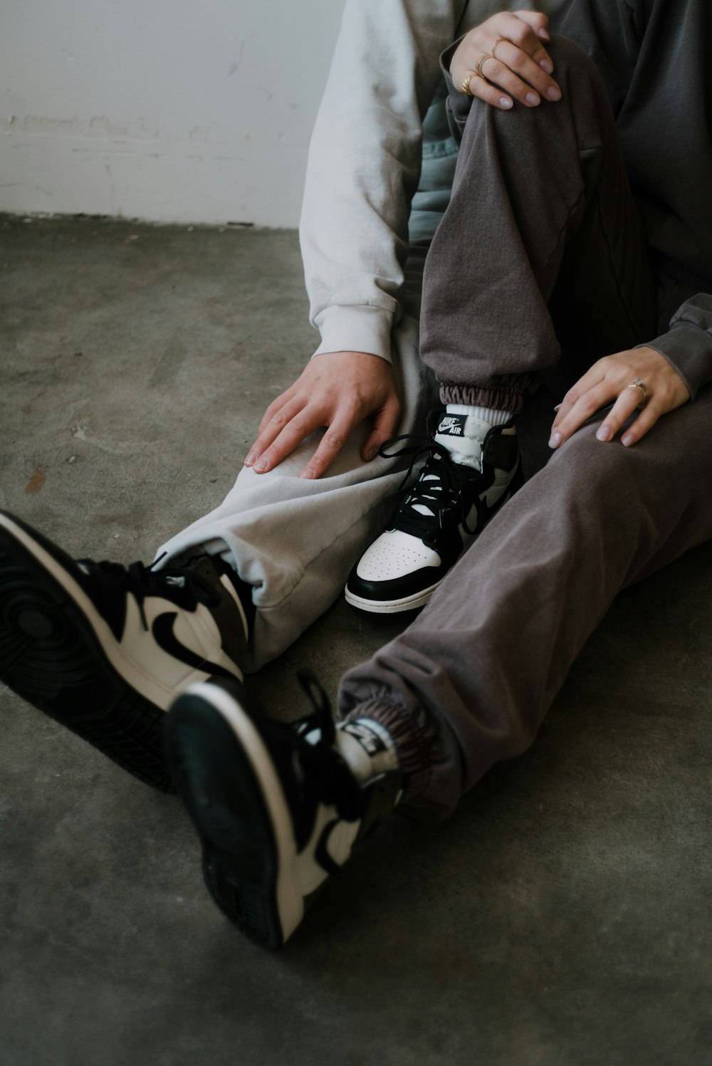 person in gray pants and black and white nike sneakers