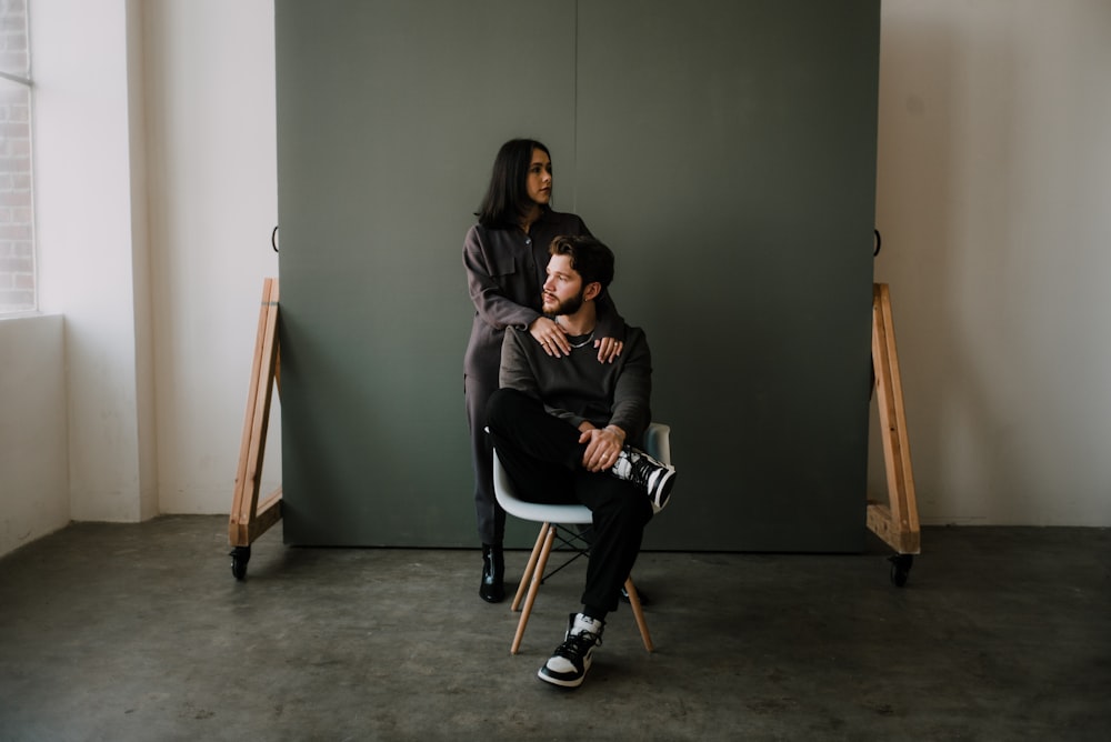 Femme en veste noire assise sur une chaise blanche