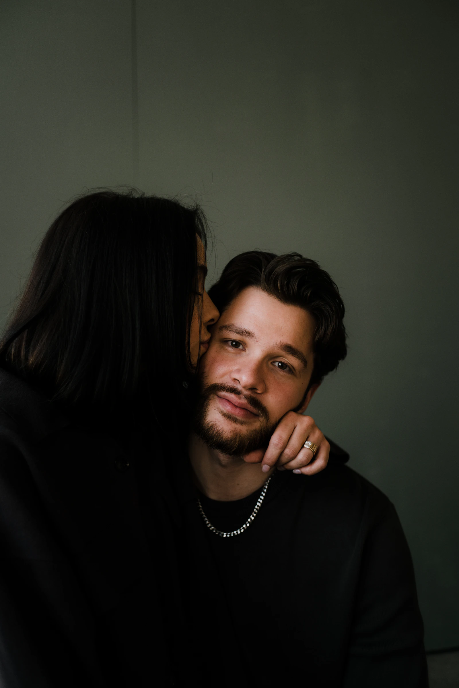 Person framed by a camera viewfinder in low-key dramatic lighting.