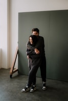 woman in black hoodie and pants sitting on brown wooden chair