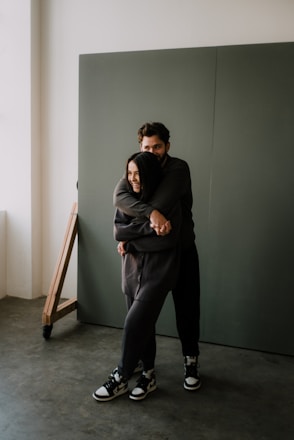 woman in black hoodie and pants sitting on brown wooden chair