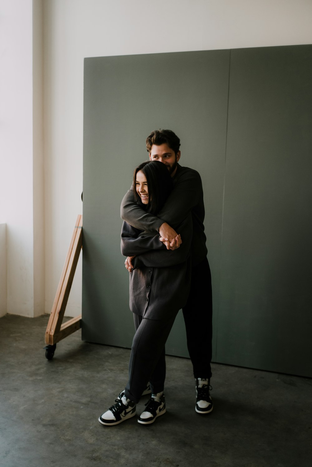 woman in black hoodie and pants sitting on brown wooden chair