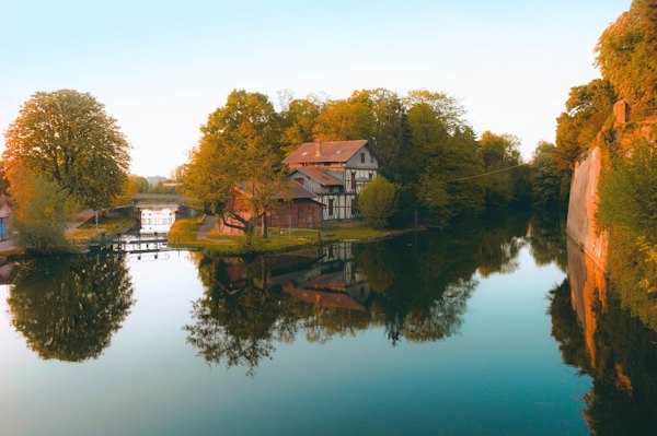 Brown and white house near body of water during daytime — Metz, France