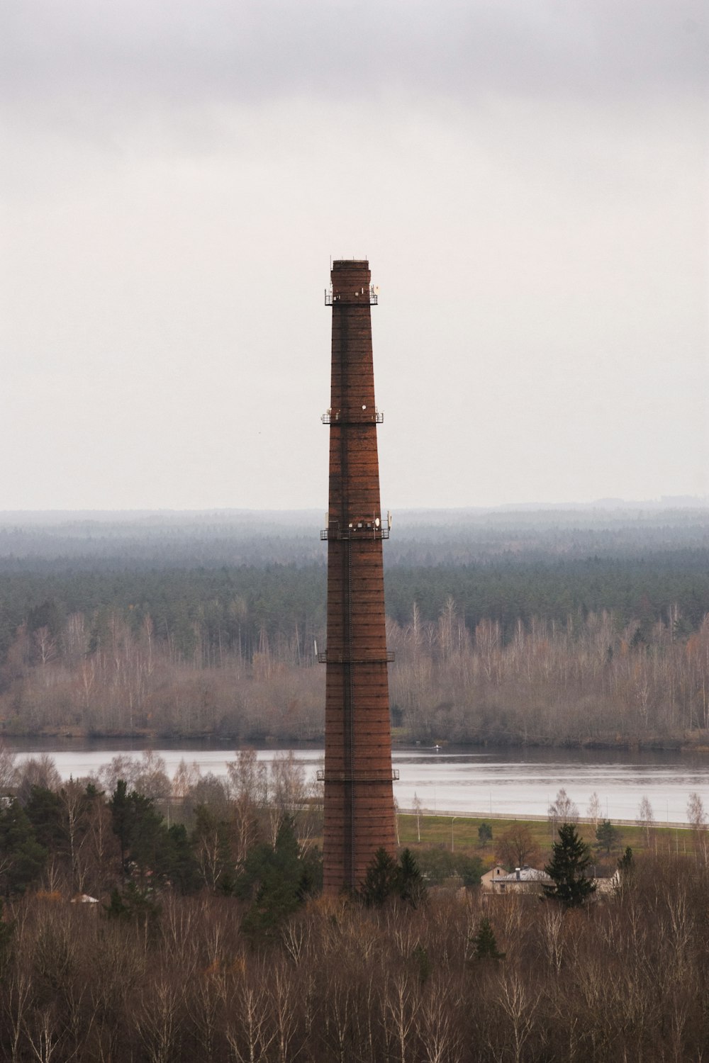 brown brick tower near green trees during daytime