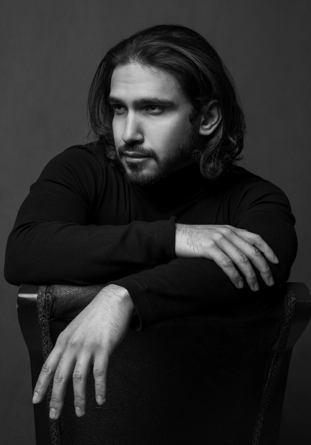 man in black long sleeve shirt sitting on chair