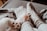 Soft, cozy socks cover human feet resting on a bed or couch, with a cat's paws visible nearby, creating a warm and relaxed setting.