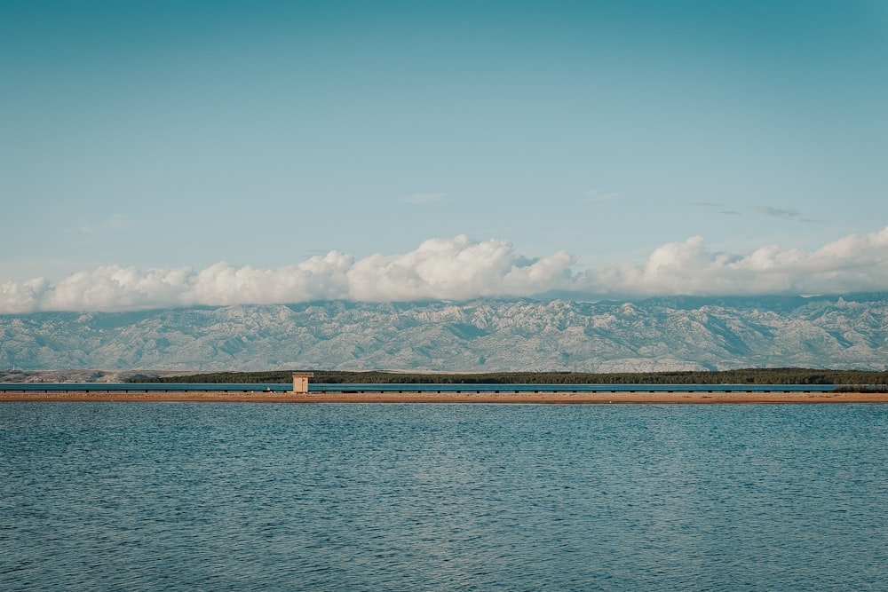 brown wooden dock on blue sea under blue sky and white clouds during daytime