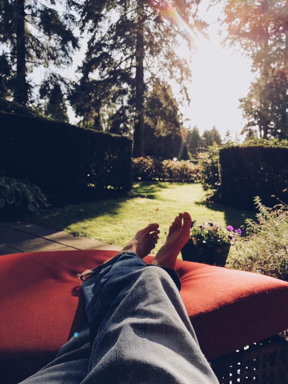 person in gray pants lying on orange textile