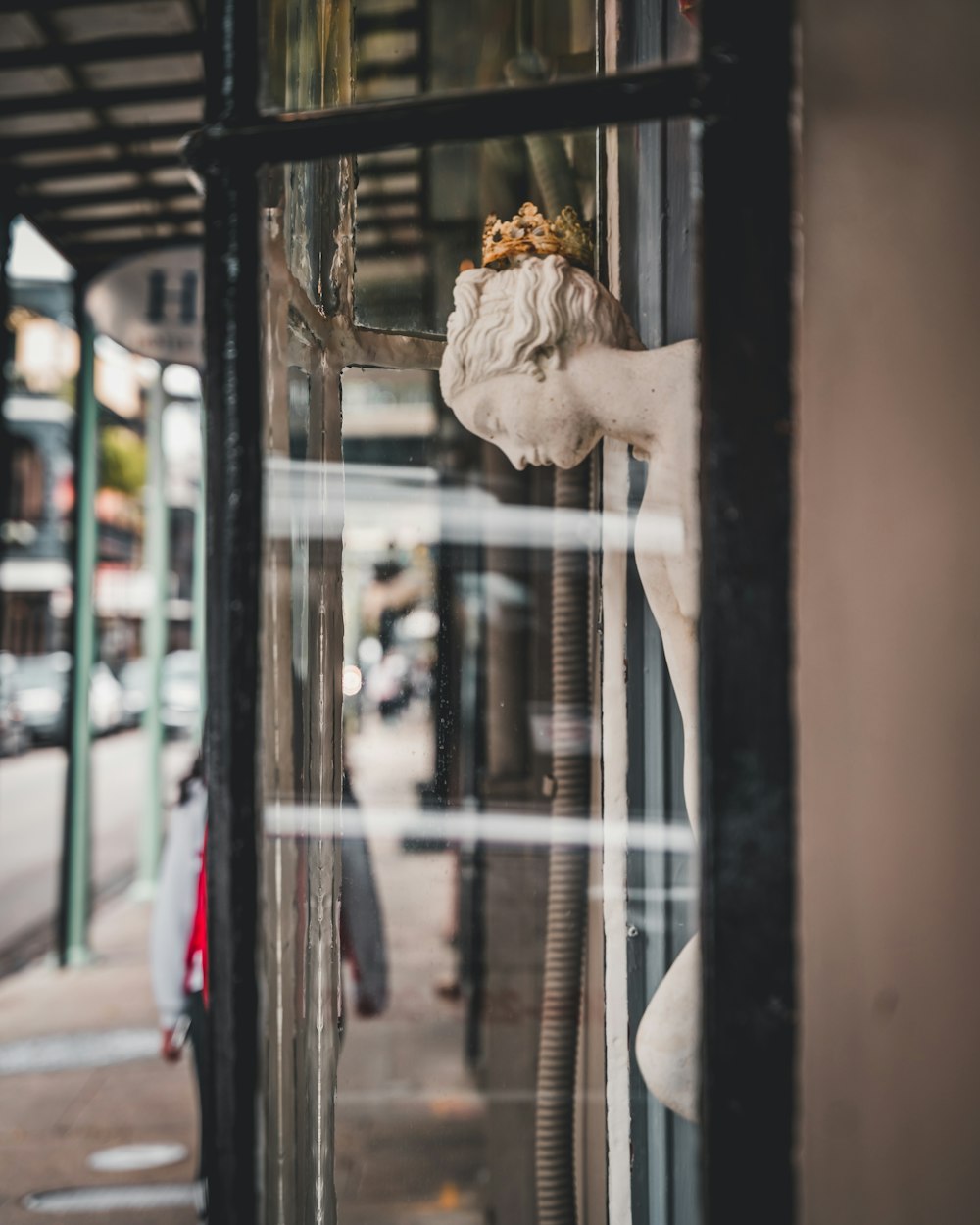 person in white dress shirt standing near glass window