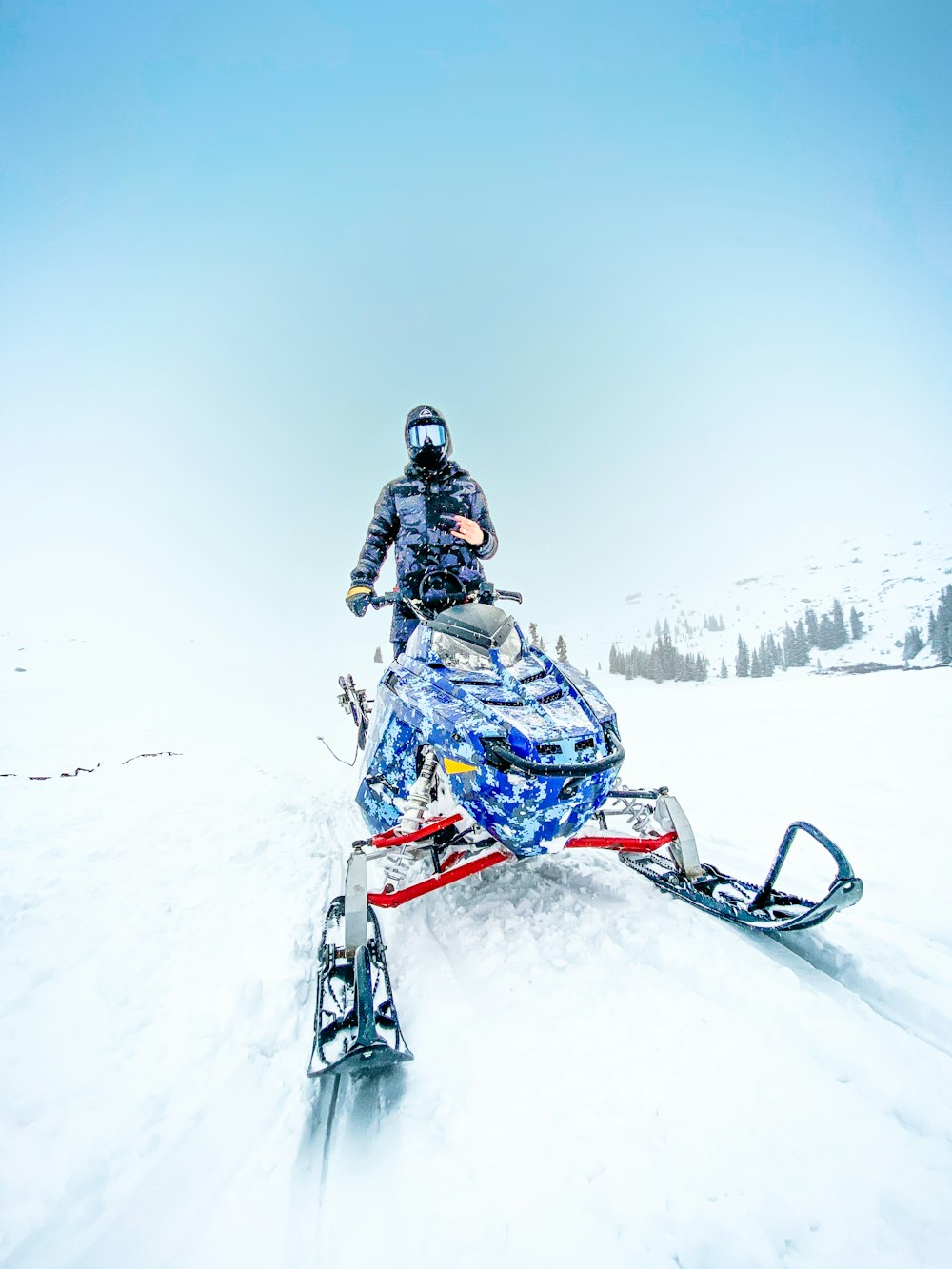 person riding blue snow ski on snow covered ground during daytime