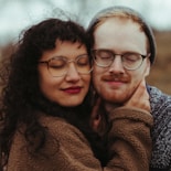 woman in brown coat wearing black framed eyeglasses