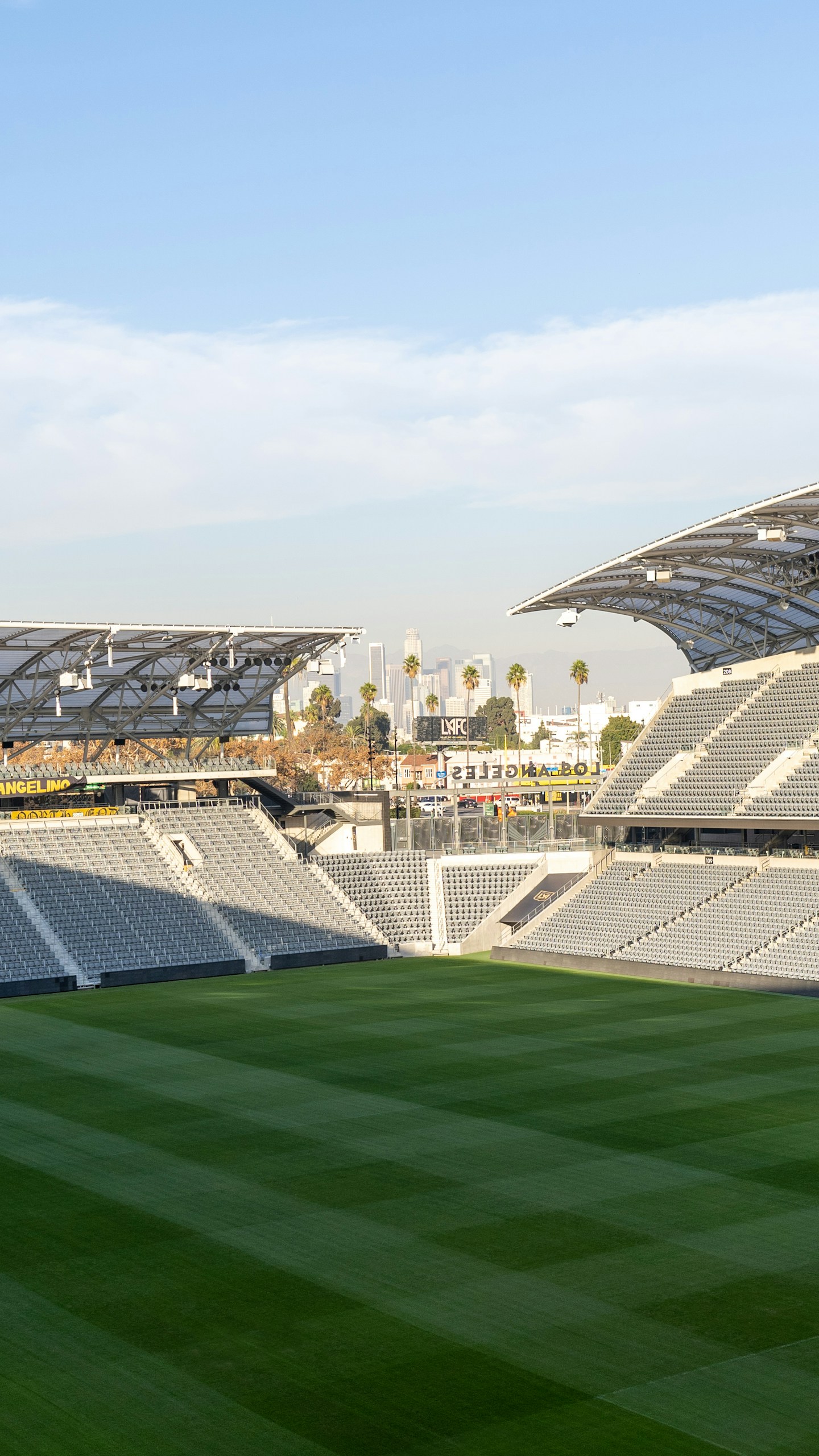 green grass field with stadium in the distance