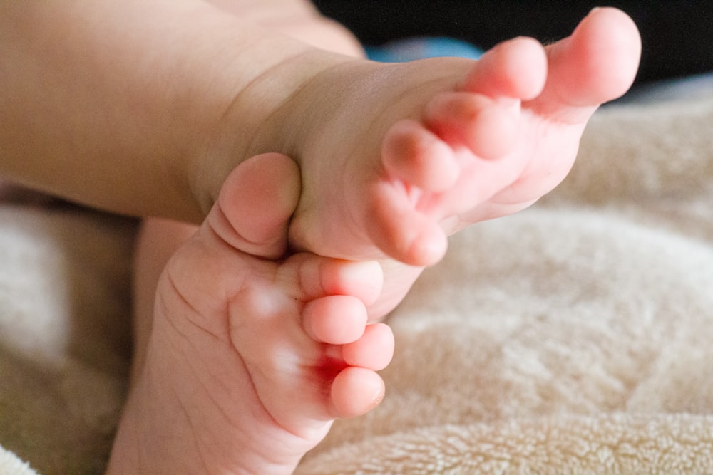 persons feet on white textile