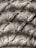 Intricate macrame pattern showcasing a series of interconnected diamond shapes, each formed by tightly knotted and looped threads. The texture is richly detailed, with depth created by the overlapping threads casting subtle shadows.