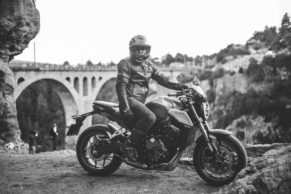 grayscale photo of man riding motorcycle